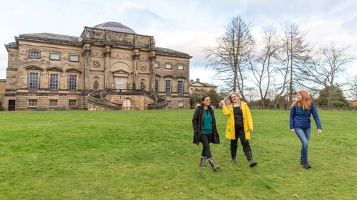 Visitors enjoying a walk across the grass in winter at Kedleston Hall, Derbyshire